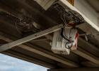 Crews assess damage and remove loose debris from the damaged support struts on the overpass.