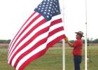 Jim Walker raising the large American flag in the morning and lowering that same flag in the evening.